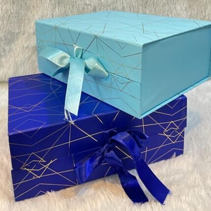 Elegant marble foiling gift boxes with gold lines and ribbons, ideal for corporate gifting displays.