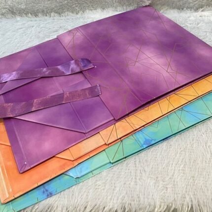 Colorful geometric gift bags with ribbons, ideal for stylish corporate gifting presentations.