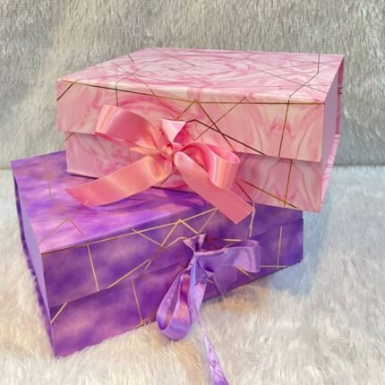 Elegant marble foiling gift boxes with gold lines and ribbons, ideal for corporate gifting presentations.