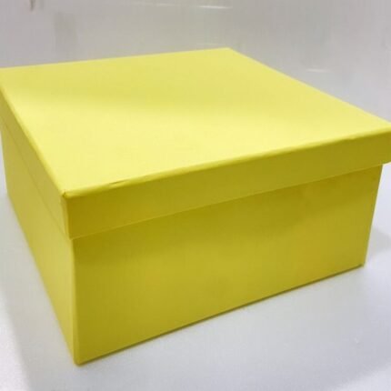 Square yellow hamper box with lid on white surface, ideal for simple, elegant corporate gifting.
