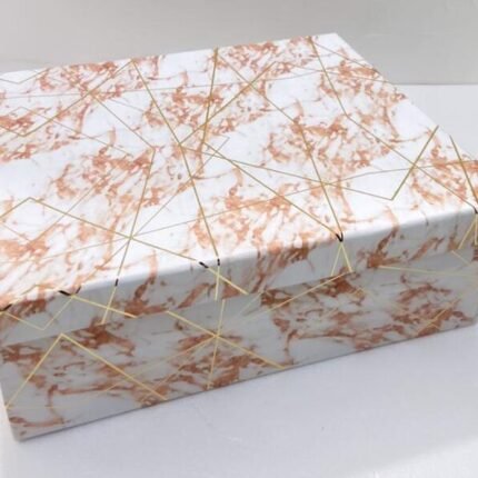 Elegant marble-patterned corporate gift hamper with gold string accents on a white surface.