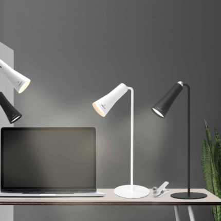 Corporate gift setup: closed laptop, Magneto Portable Lights, wall lamps, and plant on a minimalist desk.